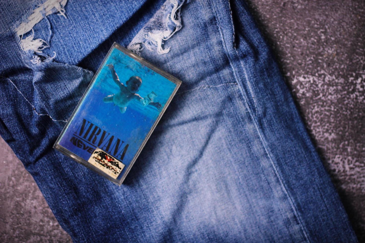 WASHINGTON, USA - September 30 2022  Nirvana's cassette tape and Ripped jeans or Torn jeans. A symbol of the grunge or Seattle sound. photo