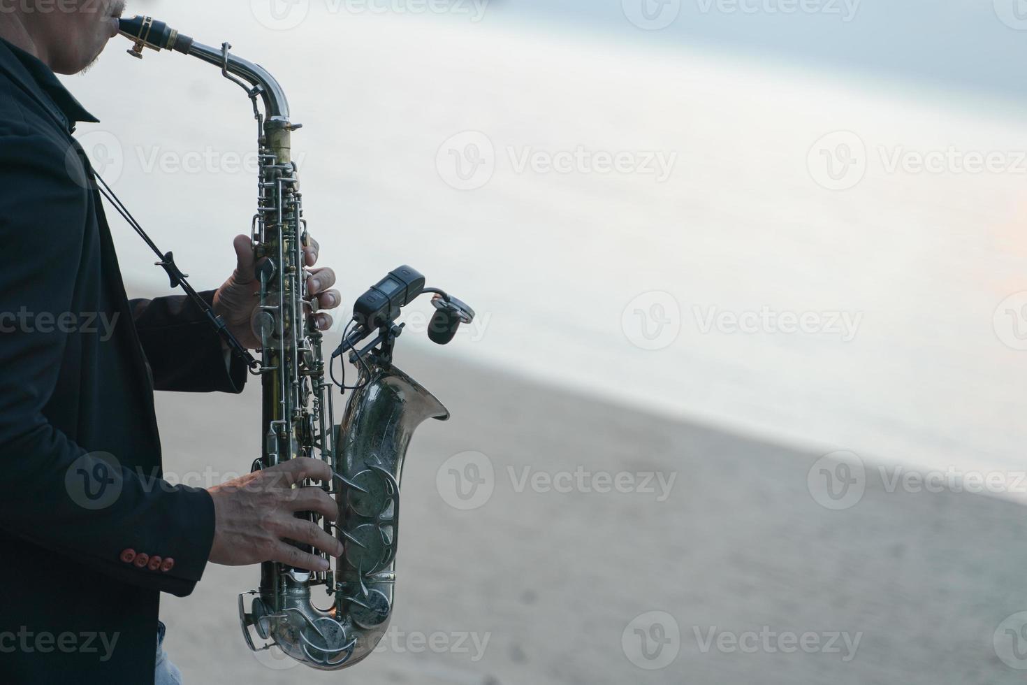 hombre músico tocando el saxofón en la playa. foto