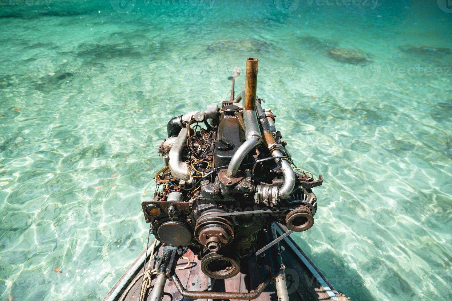 Old Machine of Fishing boat at the clear blue sea water in Thailand. photo