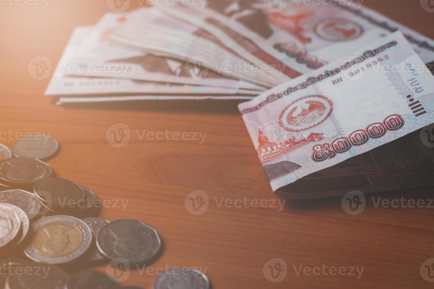 Closeup Shot Of Lao KIP Currency And Thai Baht Coin Exchange And closeup-shot-of-lao-kip-currency-and-thai-baht-coin-exchange-and
