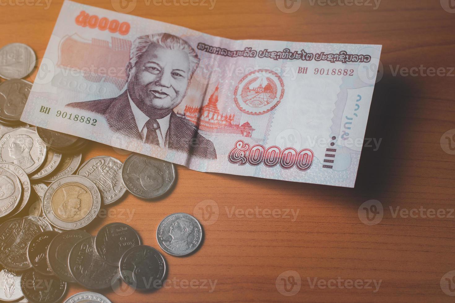 Closeup Shot Of Lao KIP Currency And Thai Baht Coin Exchange And 