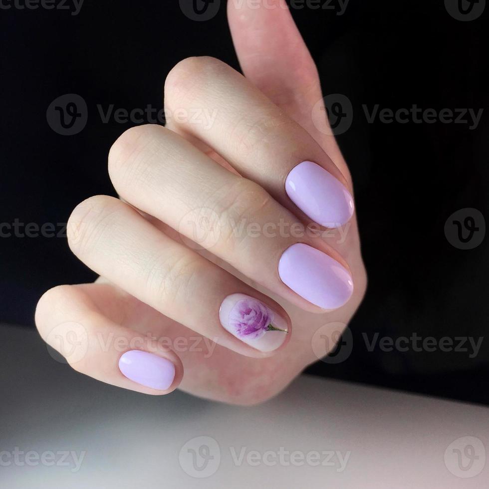 elegante manicura rosa femenina de moda. manos de una mujer con manicura rosa en las uñas foto