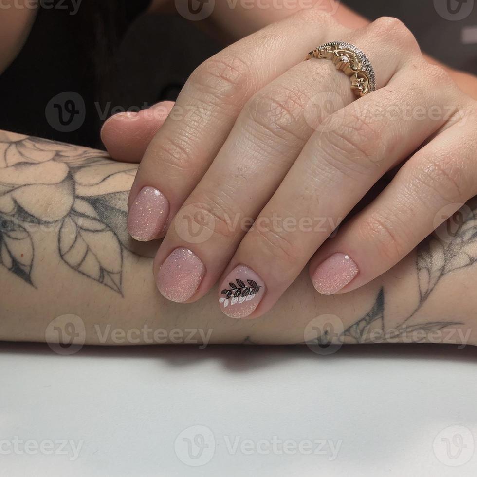 Tattooed hand with manicure photo