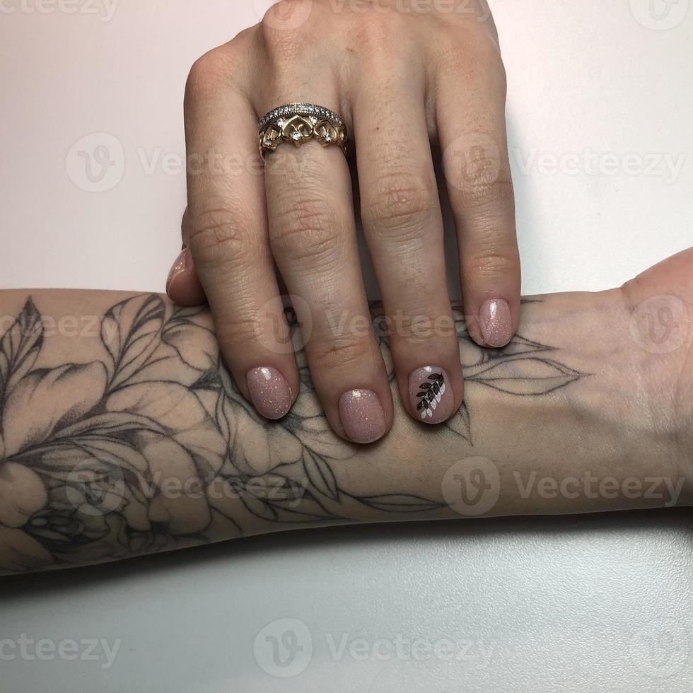 Tattooed hand with manicure photo