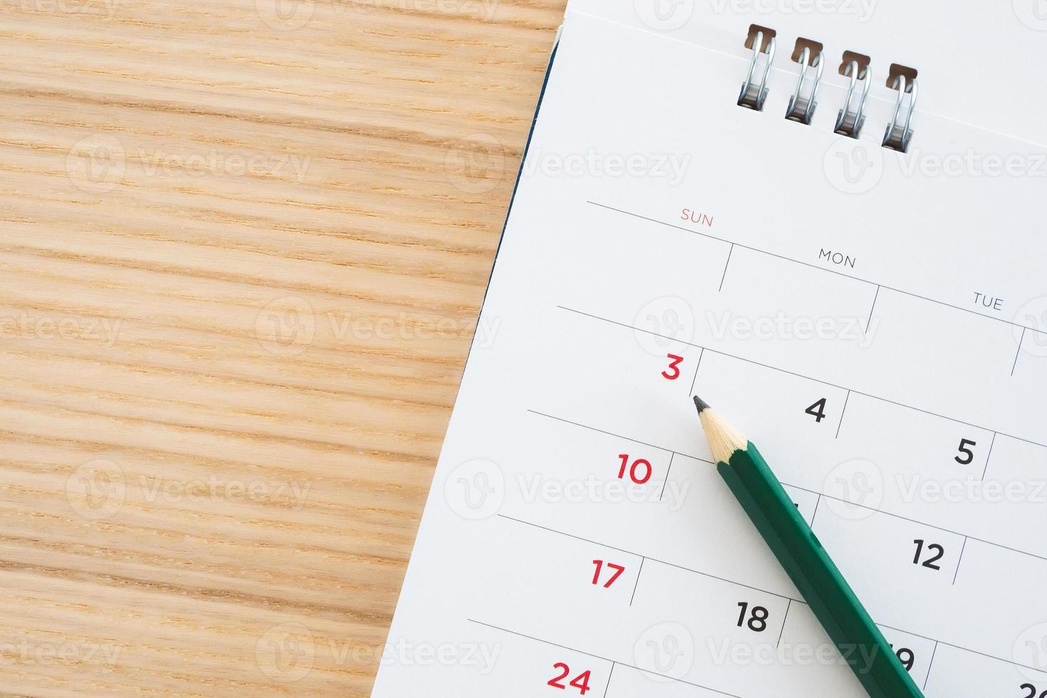 calendar page with pencil on wood table background photo