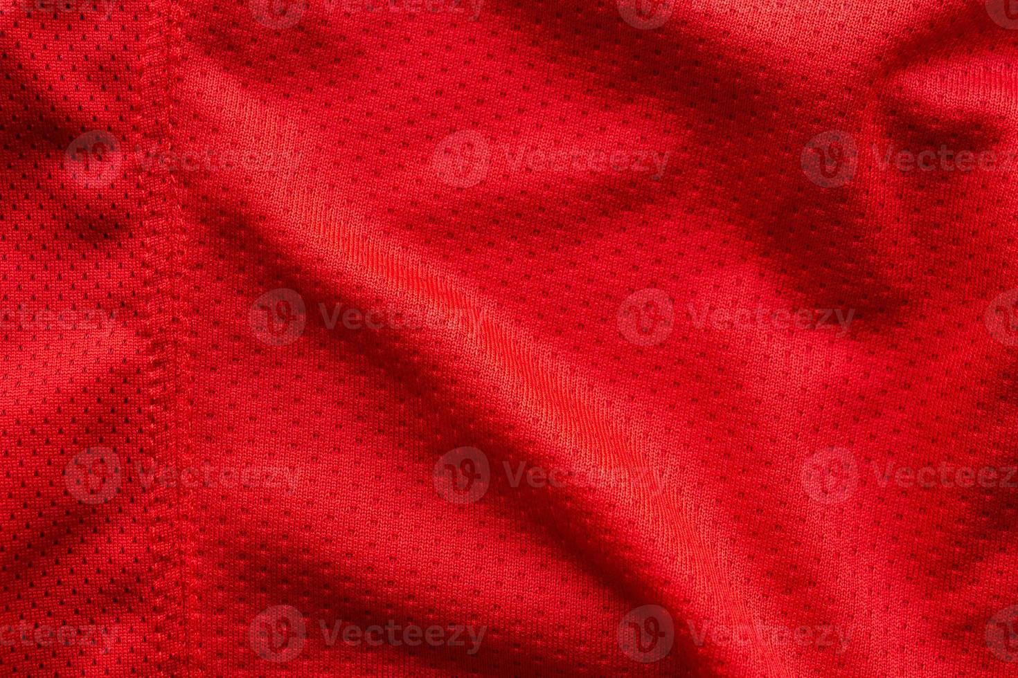 Red fabric sport clothing football jersey with air mesh texture background photo