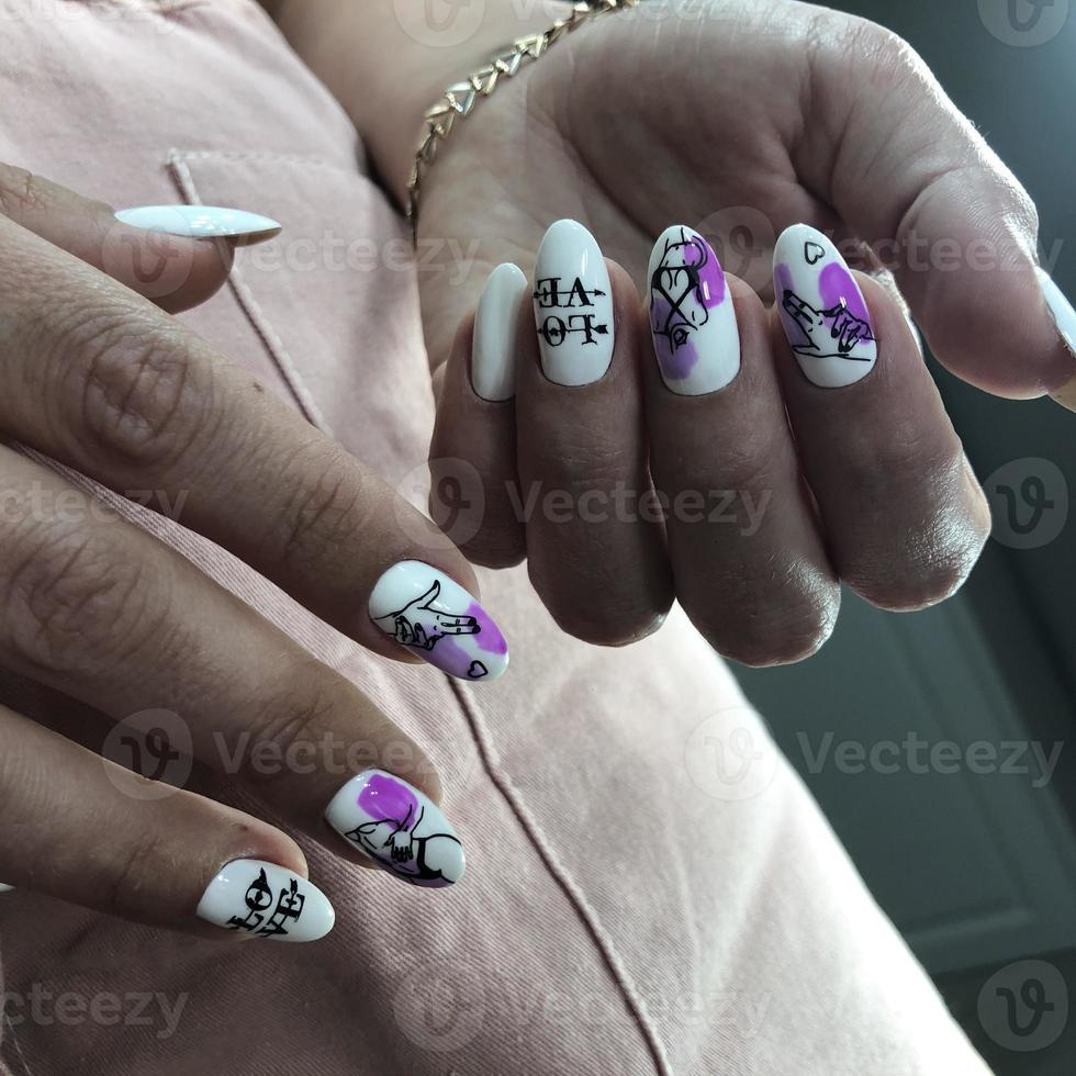 manos de mujer con uñas blancas y diseño de amor foto