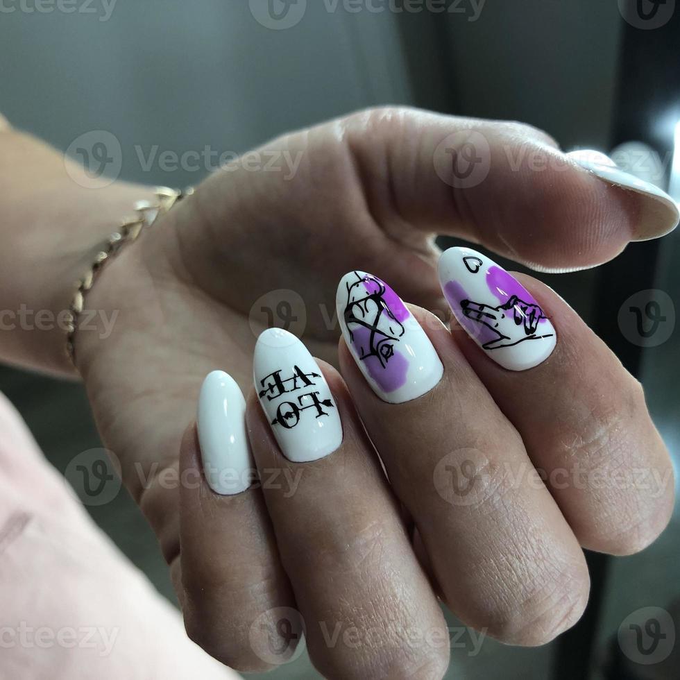 manos de mujer con uñas blancas y diseño de amor foto