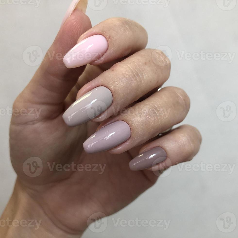 Stylish trendy female pink manicure.Hands of a woman with pink manicure on nails photo