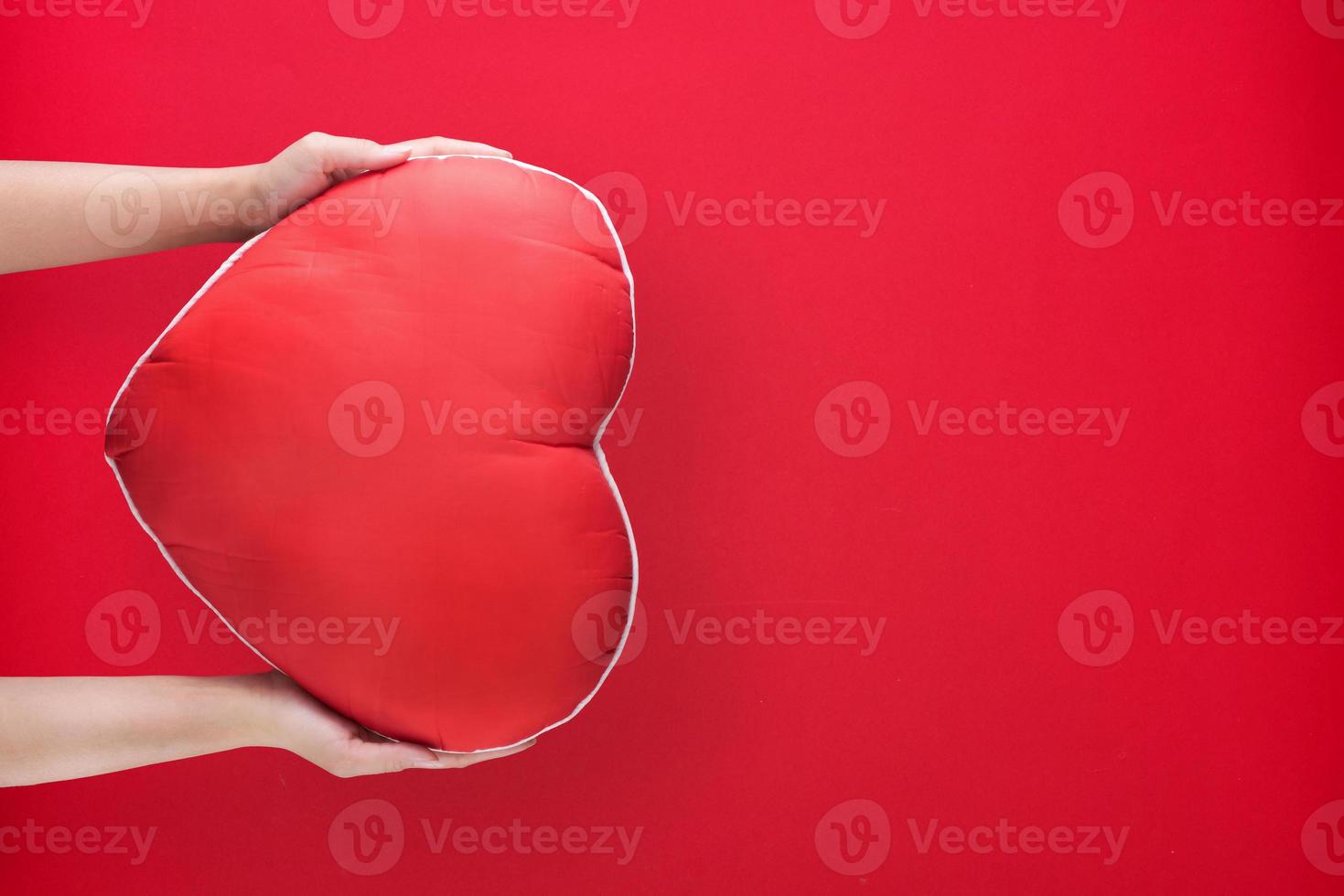 hand holding red heart on paper background with copy space for love wedding or valentines day photo