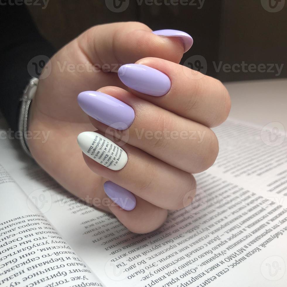 Stylish trendy female purple manicure with design.Hands of a woman with purple manicure on nails photo