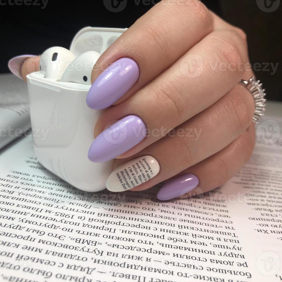 Stylish trendy female purple manicure with design.Hands of a woman with purple manicure on nails photo