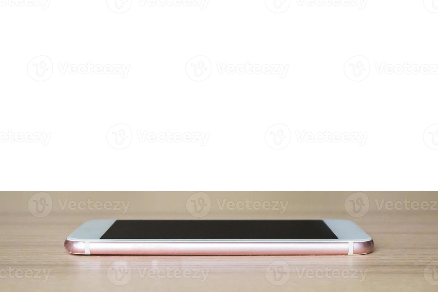 teléfono inteligente móvil en la mesa de madera aislado sobre fondo blanco foto