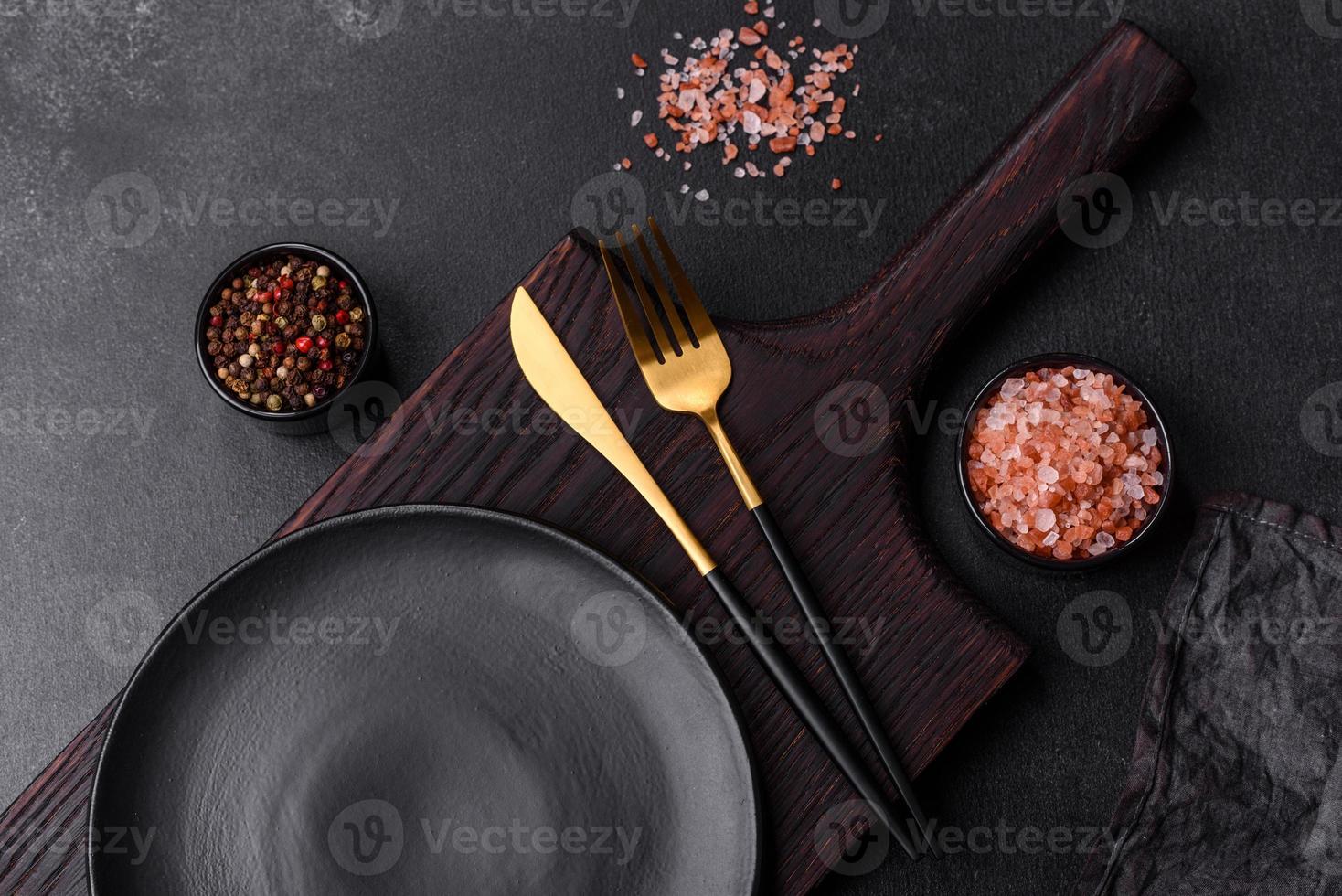 Empty black plate over dark stone background with free space. Top view photo