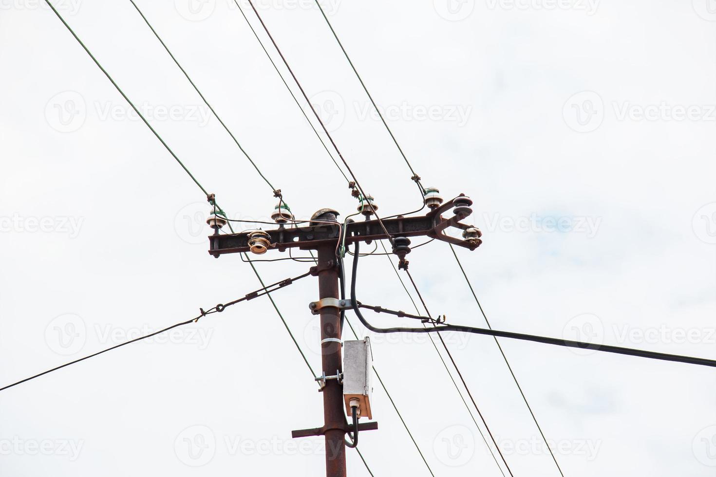 poste eléctrico líneas eléctricas cables eléctricos salientes contra el cielo azul de nubes. foto