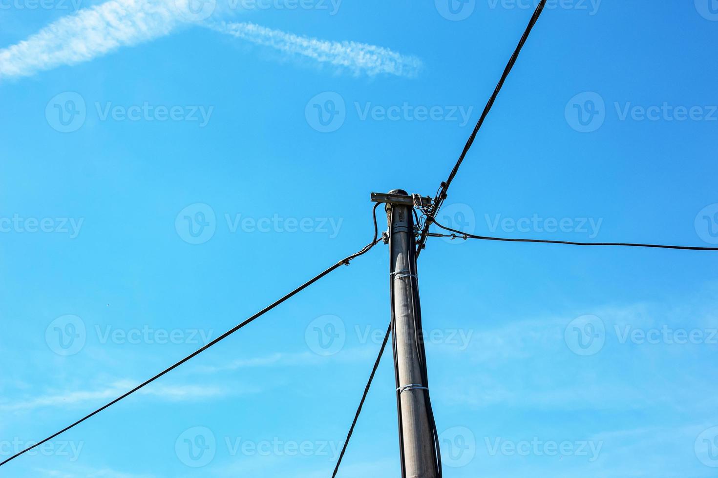 poste eléctrico líneas eléctricas cables eléctricos salientes contra el cielo azul de nubes. foto