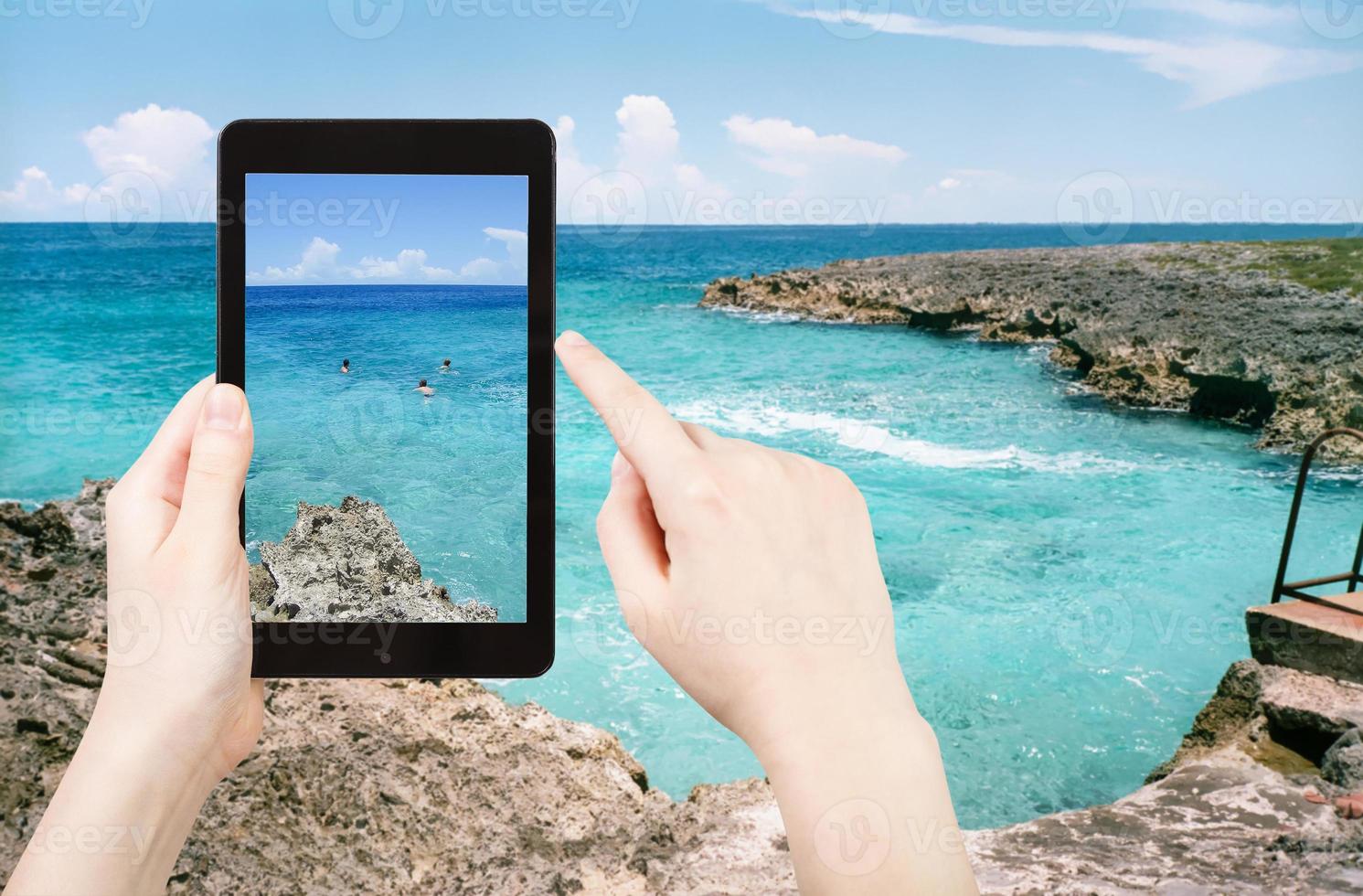 tourist taking photo of stone coastline of Caribbean Sea