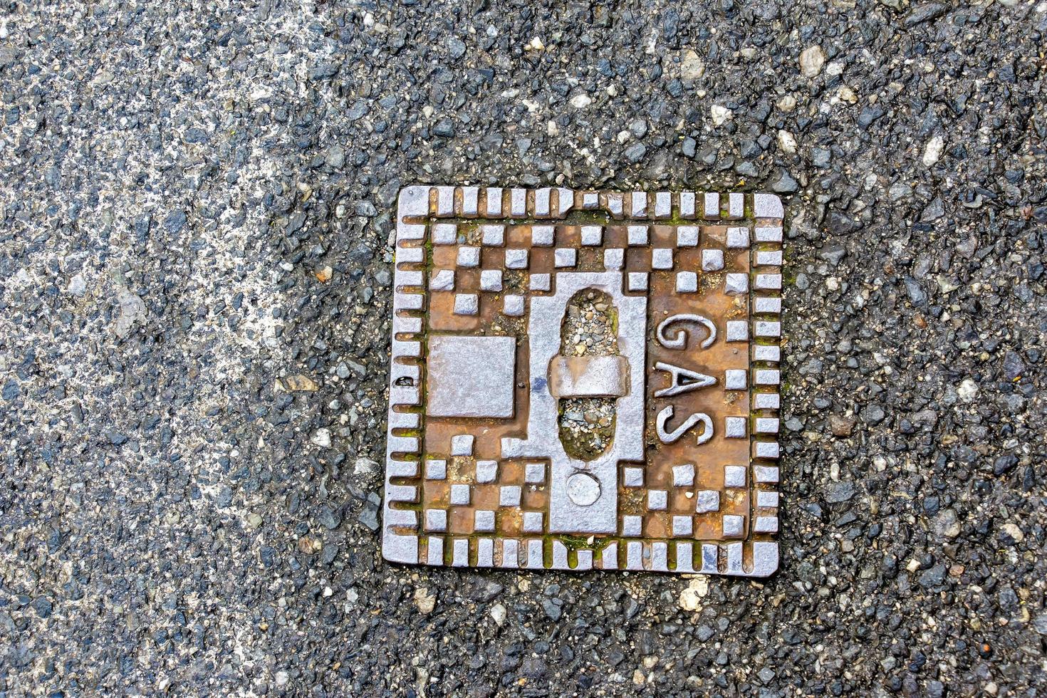 Manhole cover of the gas pipeline system. A massive metal hatch for access to city communications in the pavement. photo