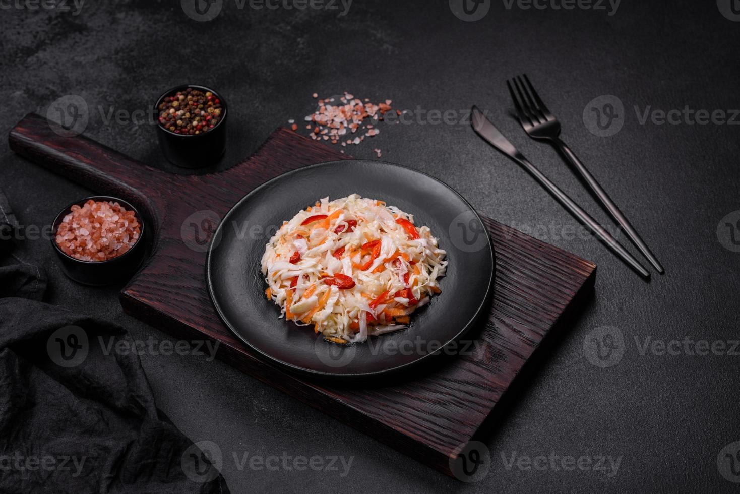 A delicious fresh vegetarian salad of white cabbage, carrot and paprika photo