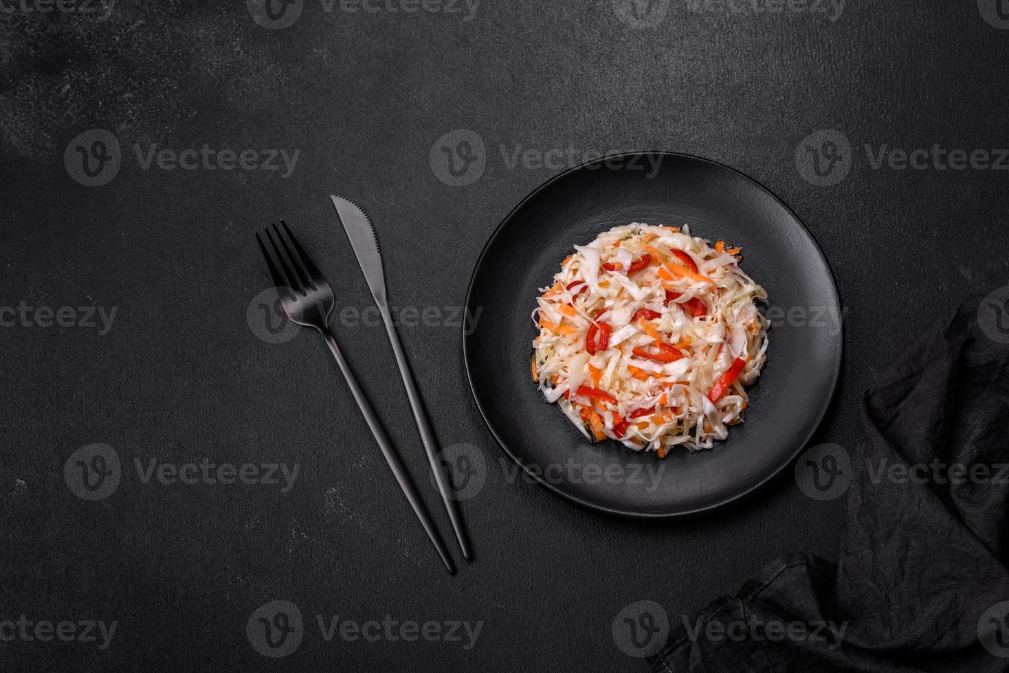 A delicious fresh vegetarian salad of white cabbage, carrot and paprika photo