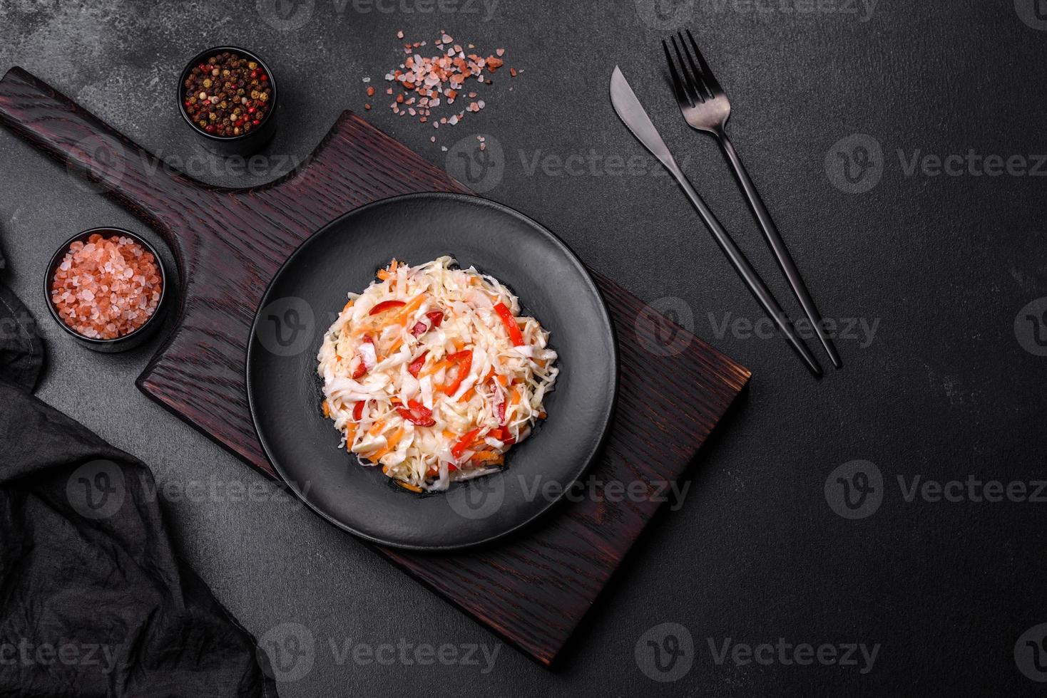 A delicious fresh vegetarian salad of white cabbage, carrot and paprika photo