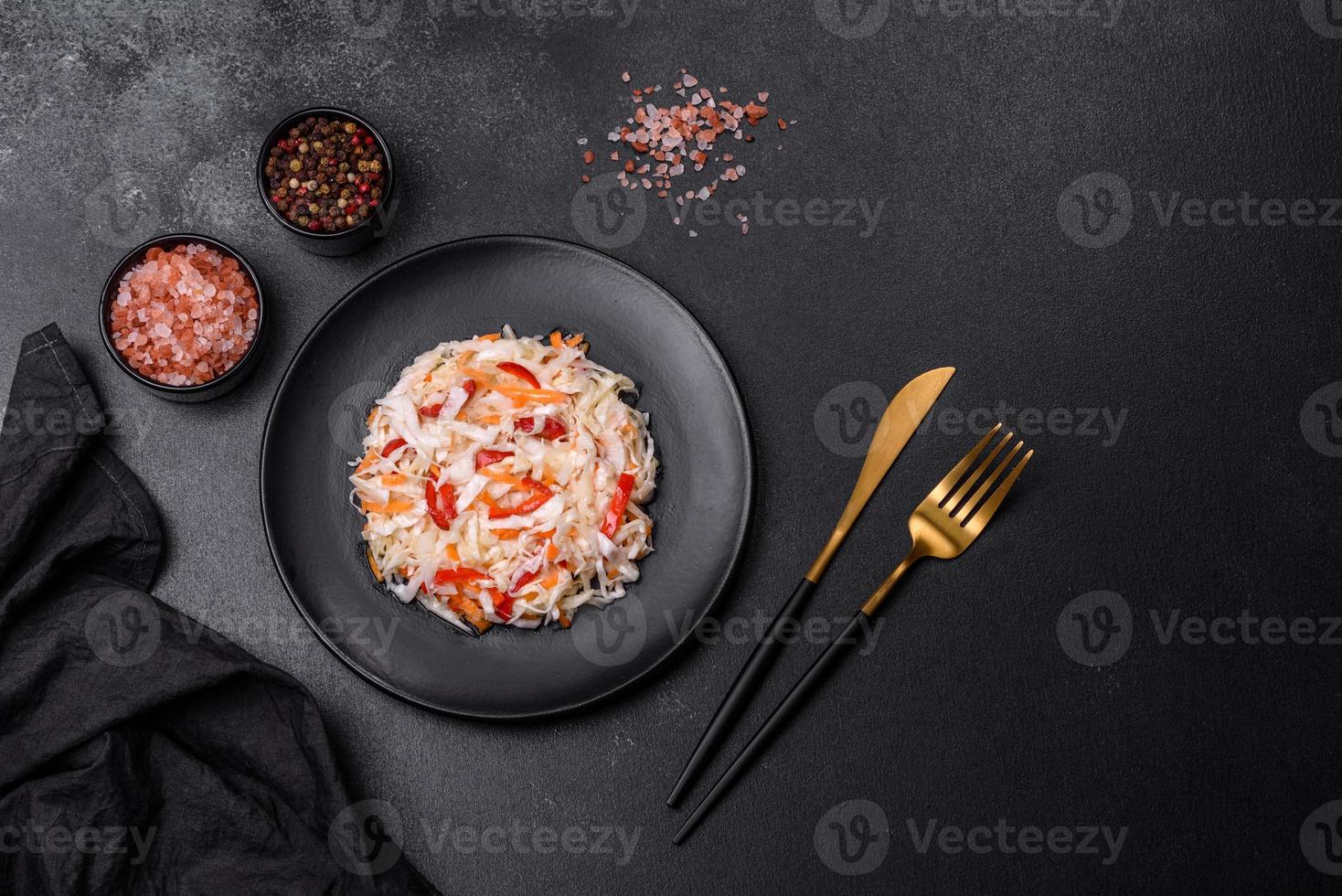 A delicious fresh vegetarian salad of white cabbage, carrot and paprika photo