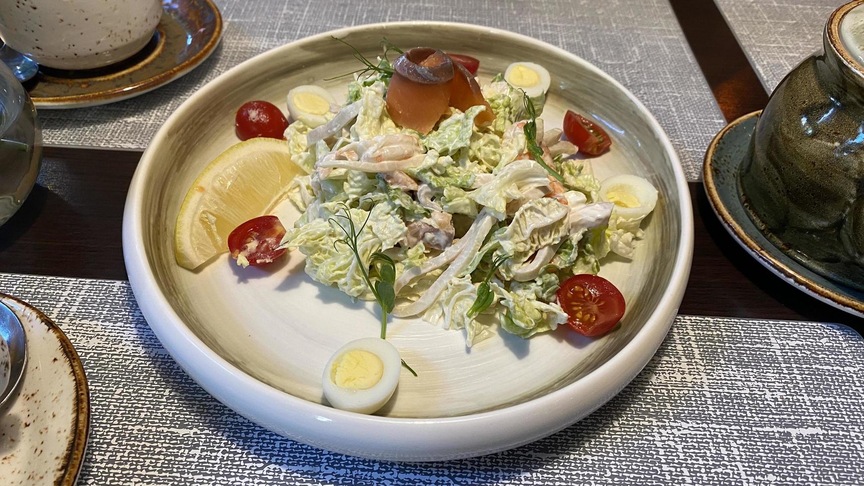 A large plate with seafood salad on the table photo