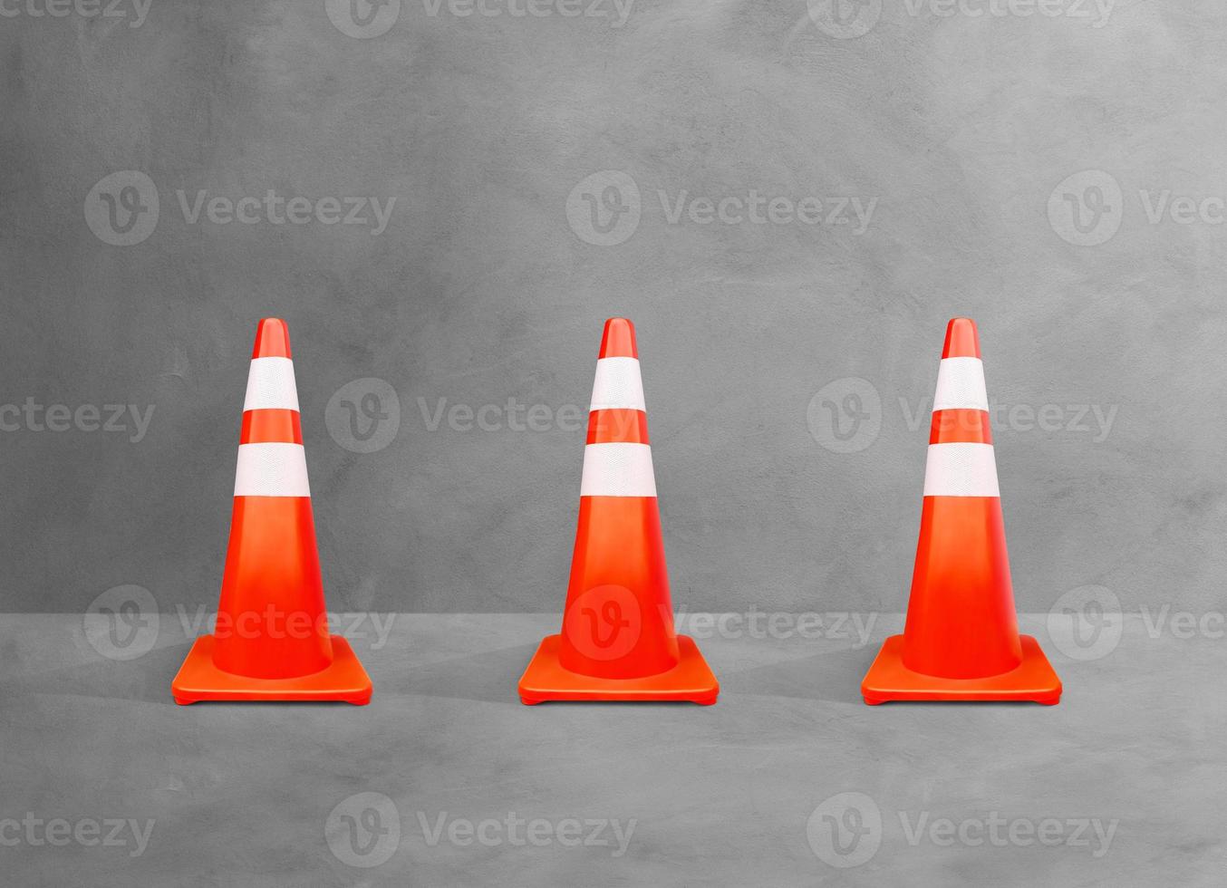 conos de tráfico, postes de color blanco-naranja, aislados en el suelo de cemento. foto
