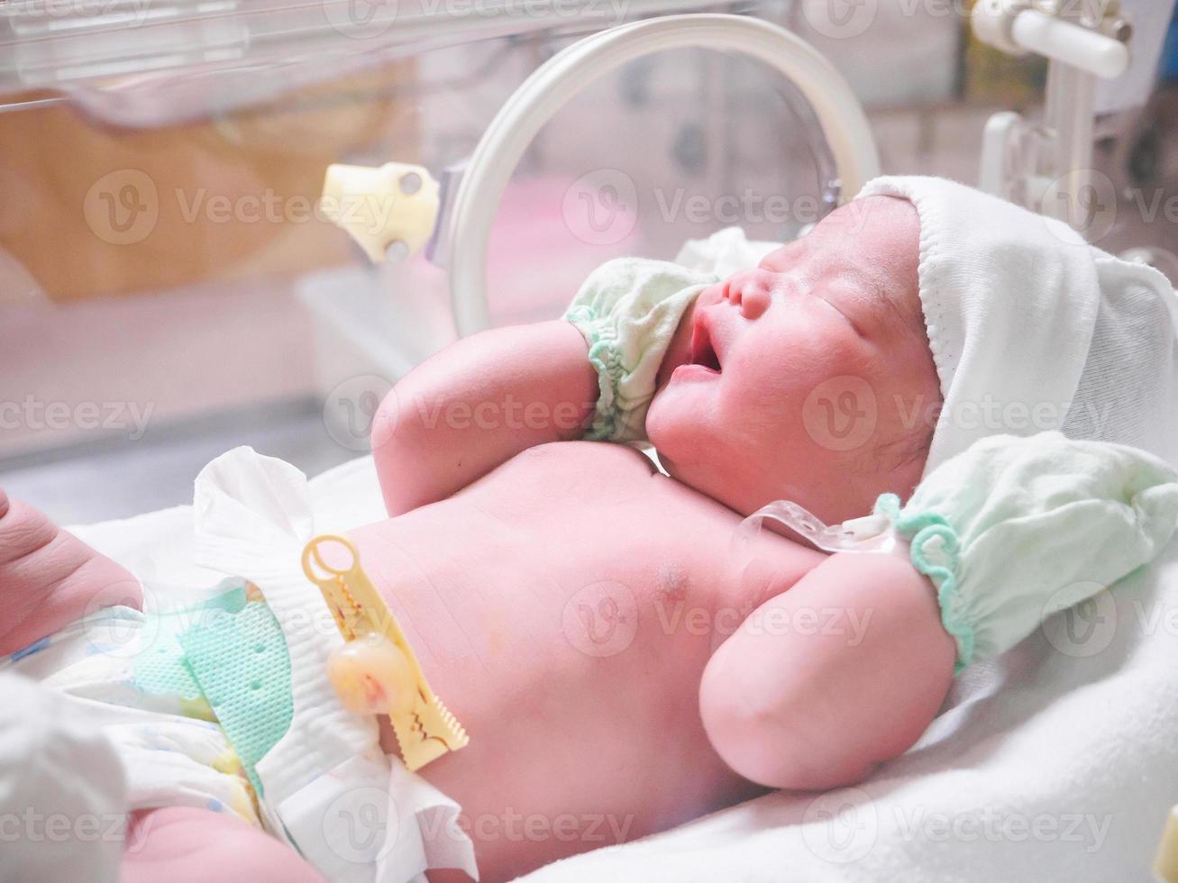 new born baby infant sleep in the incubator at hospital photo