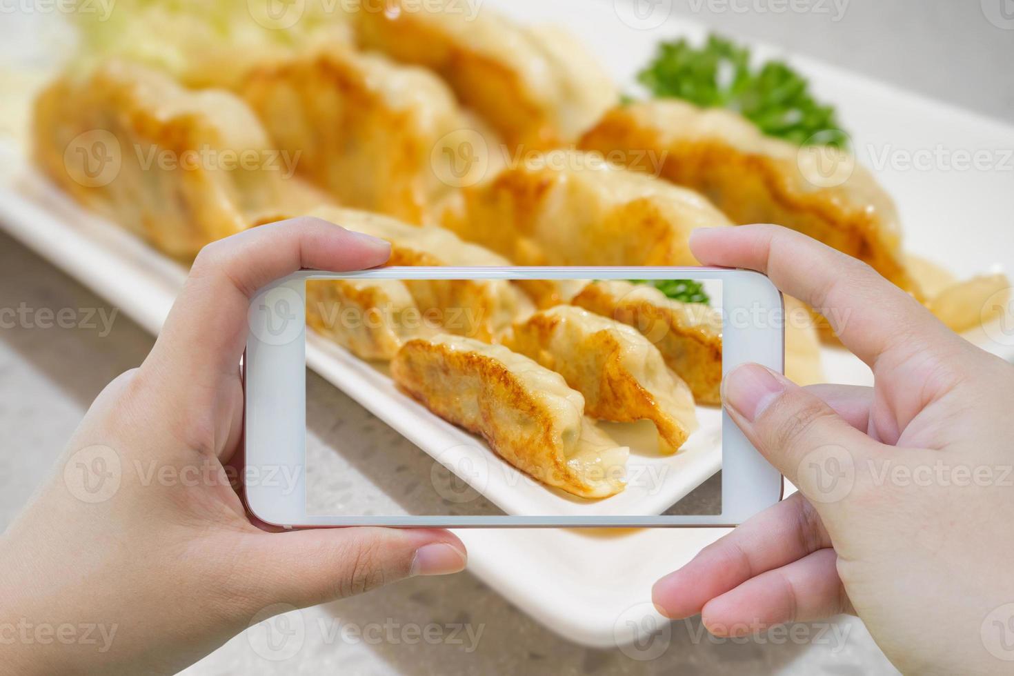 tomando fotos de albóndigas de gyoza con un teléfono inteligente