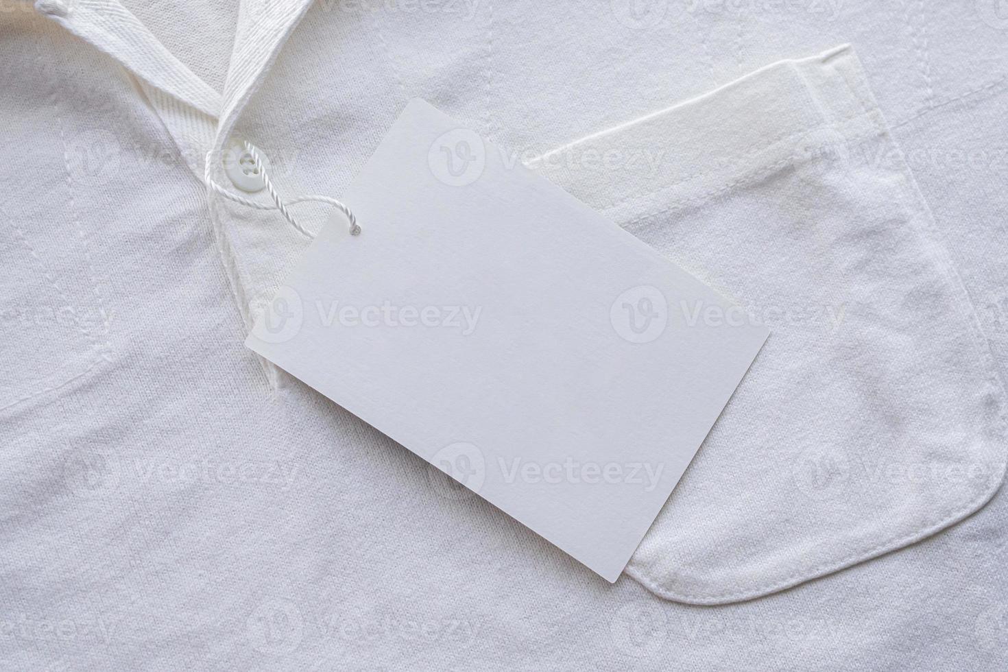 Blank white clothes tag label on new shirt photo