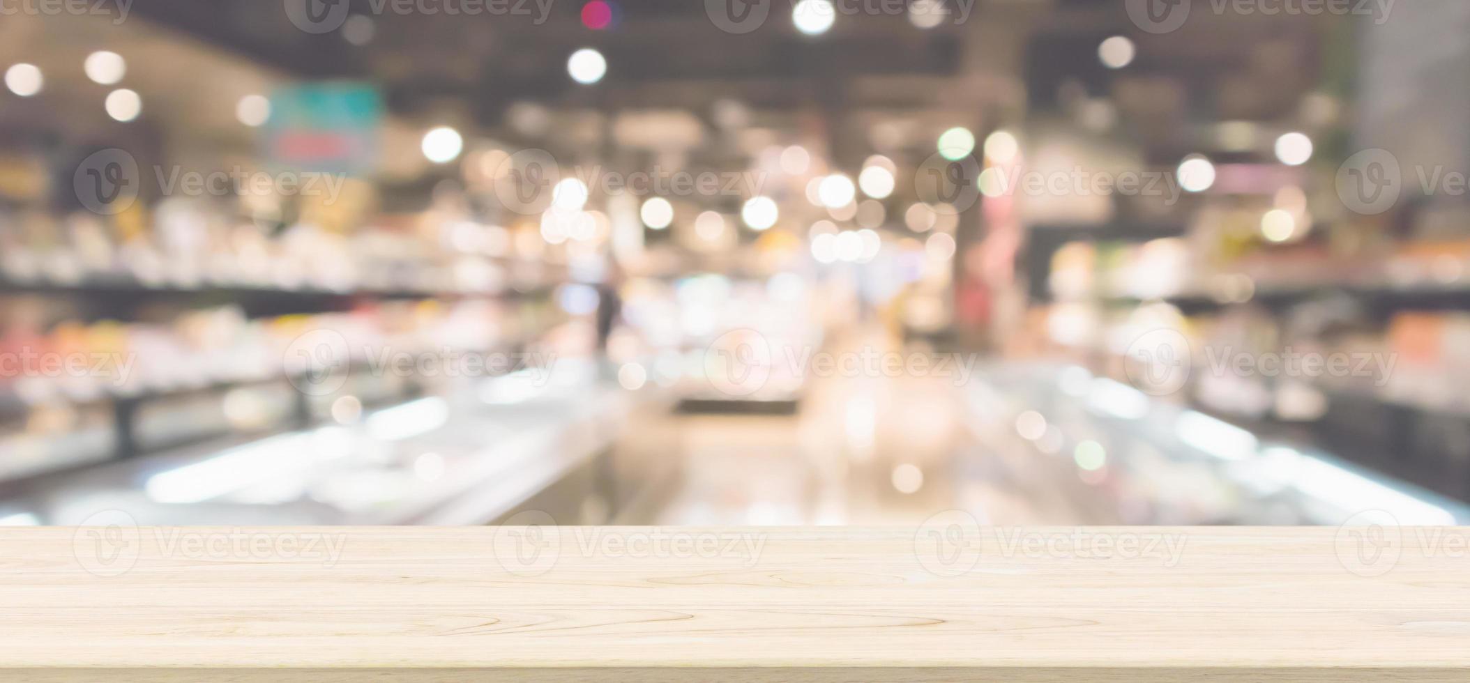 Wood table top with Abstract supermarket grocery store refrigerator blurred defocused background with bokeh light photo