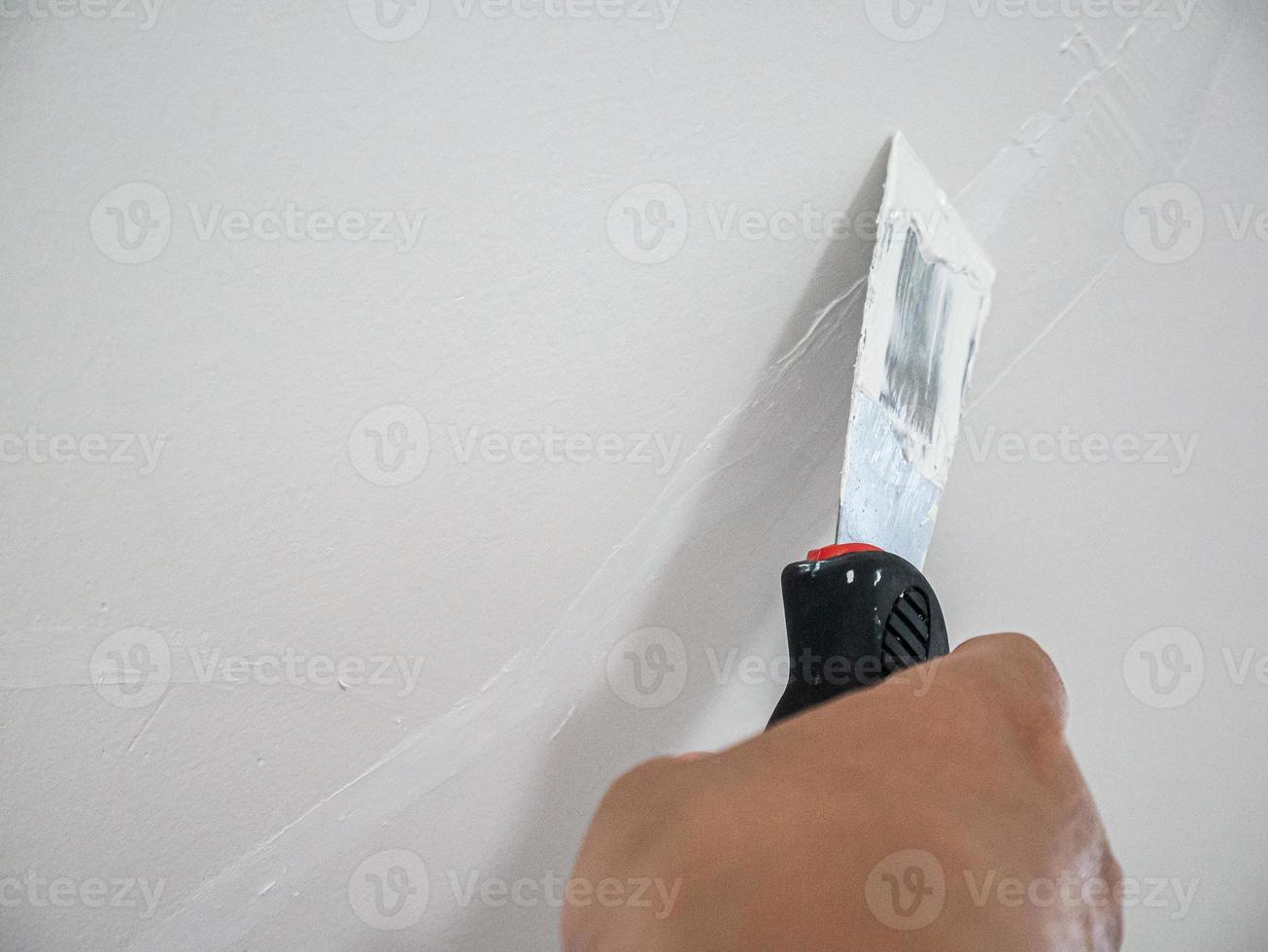 Plasterer hand repair crack white wall photo