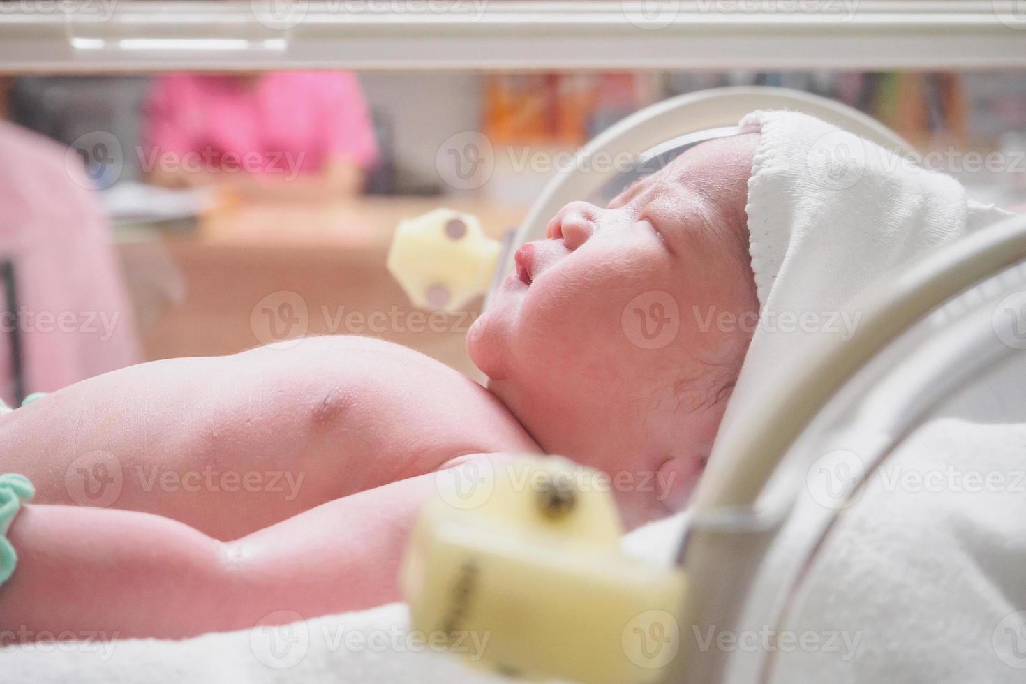 bebé recién nacido duerme en la incubadora del hospital foto