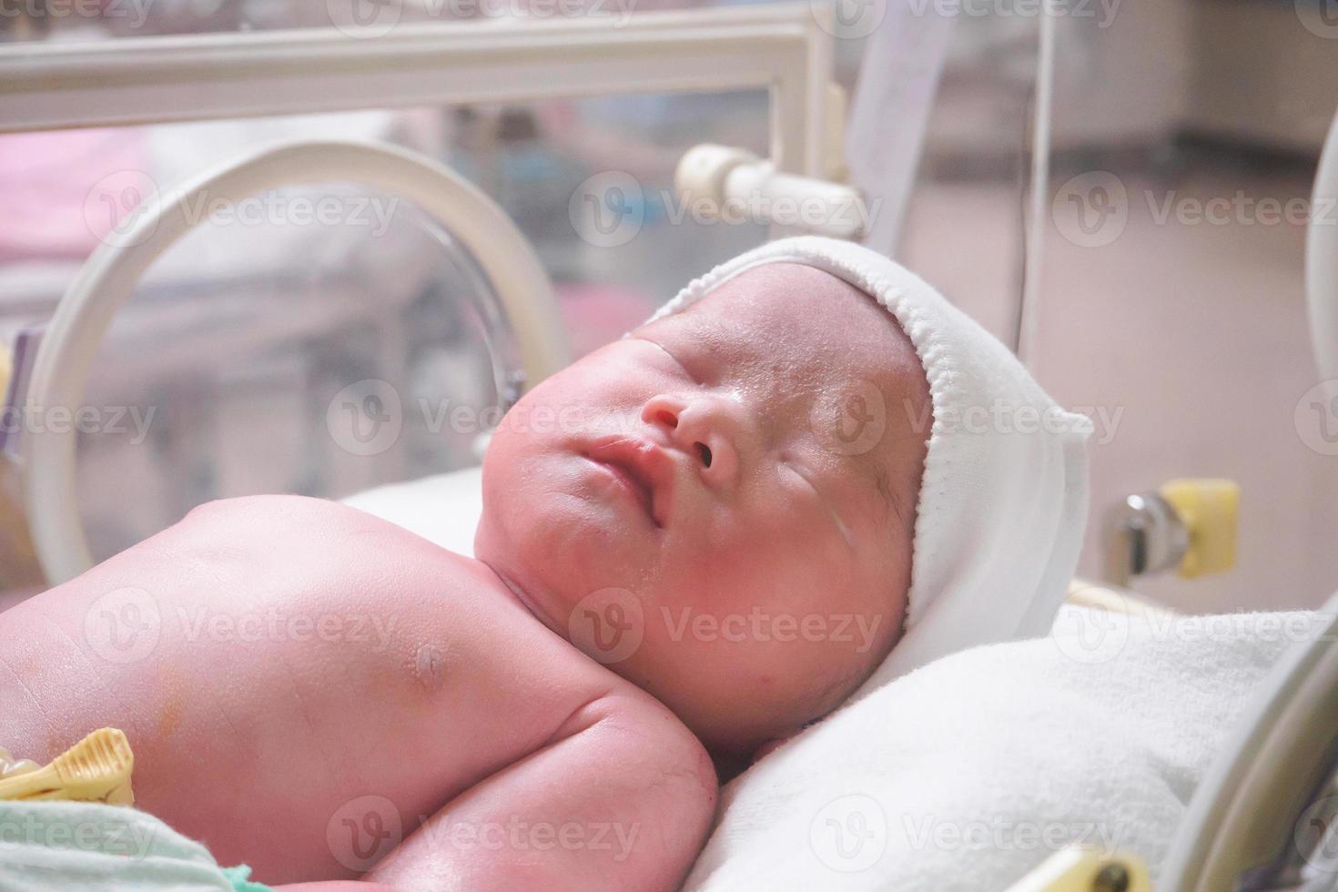 new born baby infant sleep in the incubator at hospital photo