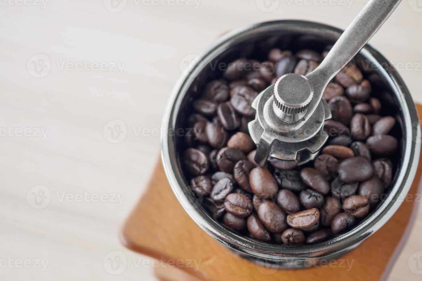 Vintage manual coffee grinder with roasted coffee beans photo