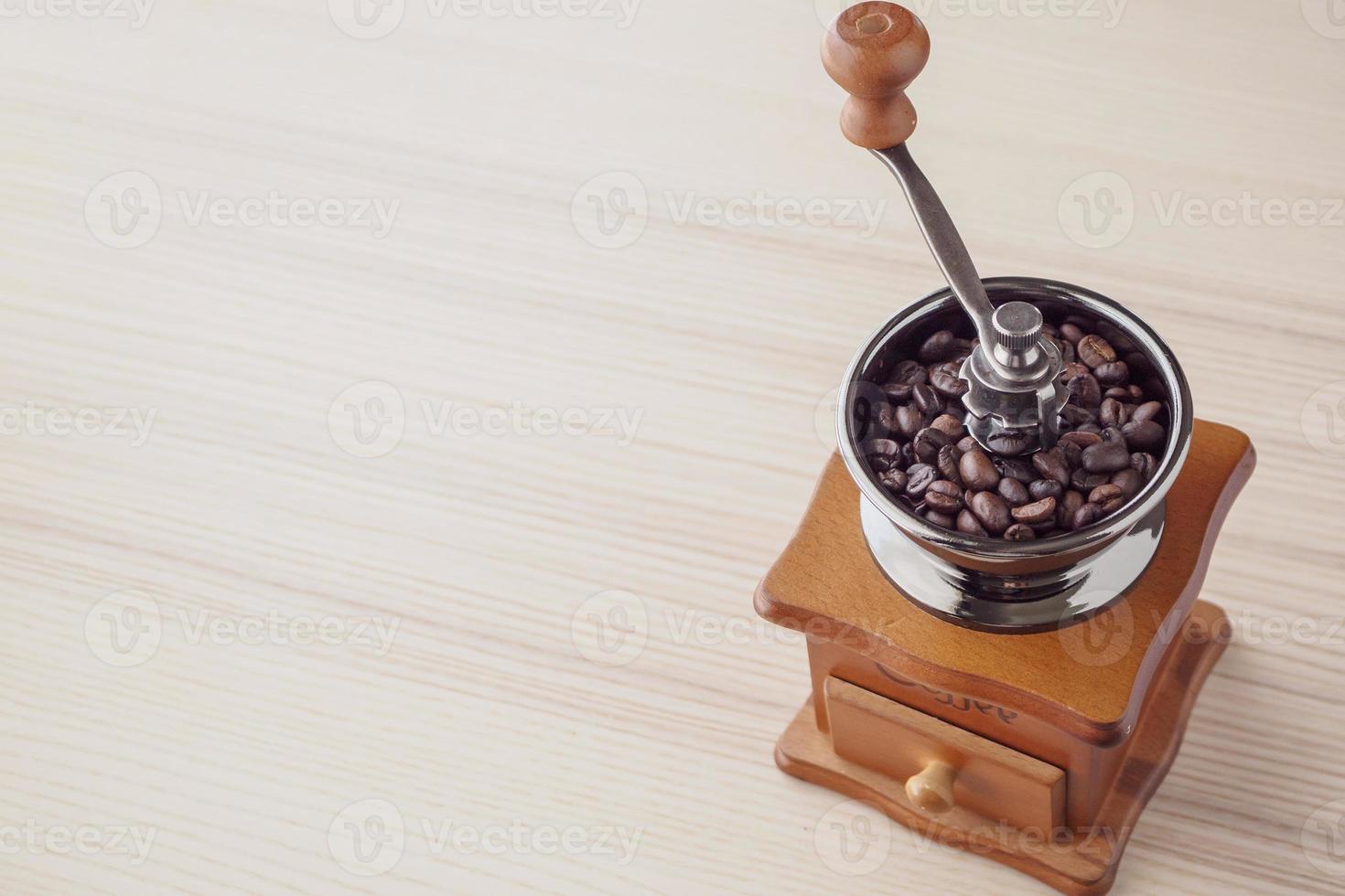 Vintage manual coffee grinder with roasted coffee beans photo