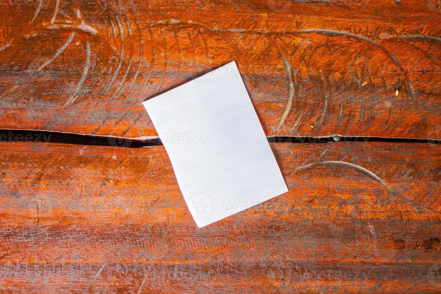 Blank white paper on old rustic wood table background photo