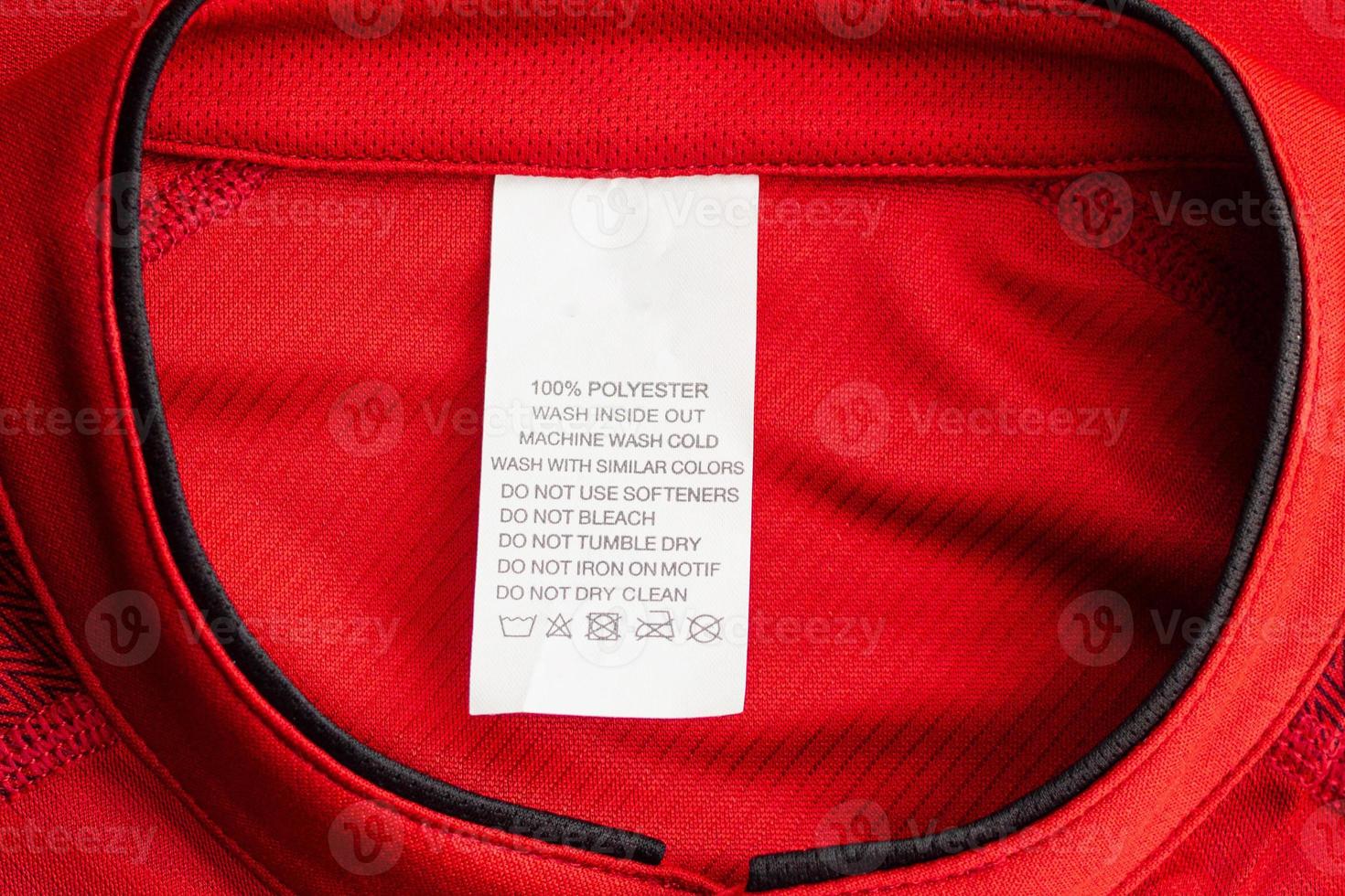 White laundry care washing instructions clothes label on red jersey polyester sport shirt photo