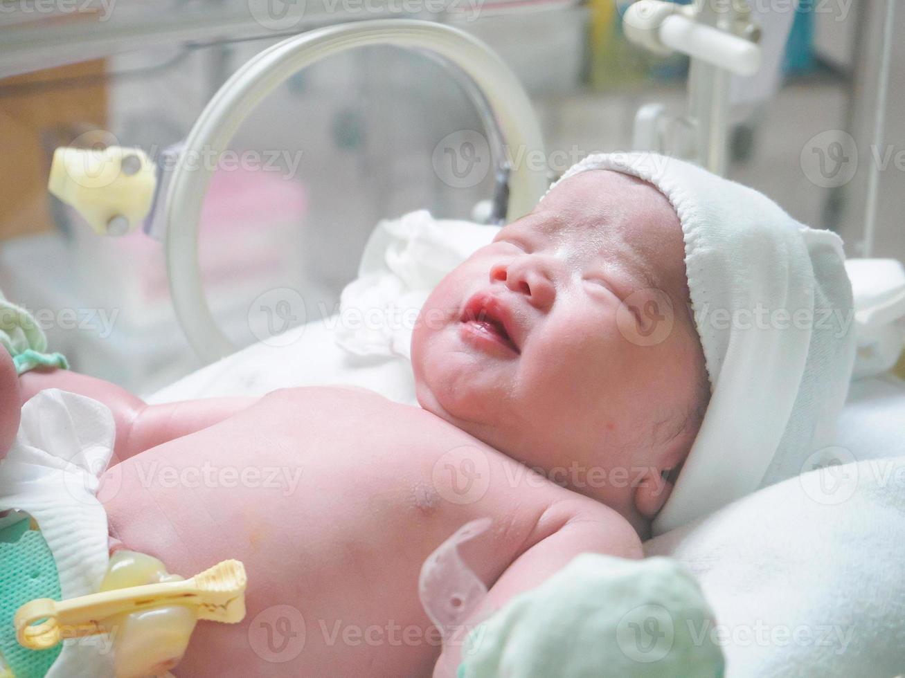 new born baby infant sleep in the incubator at hospital photo