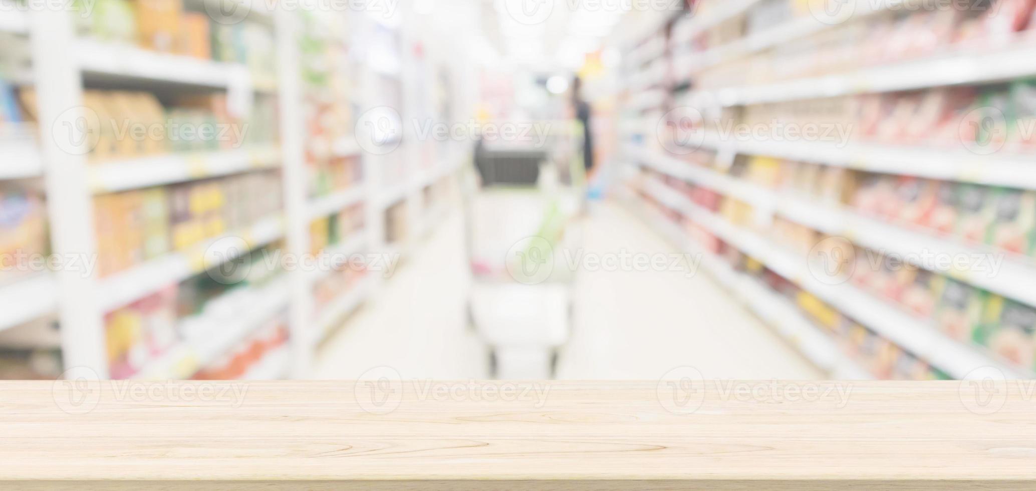 Wood table top with supermarket aisle blur background for product display photo