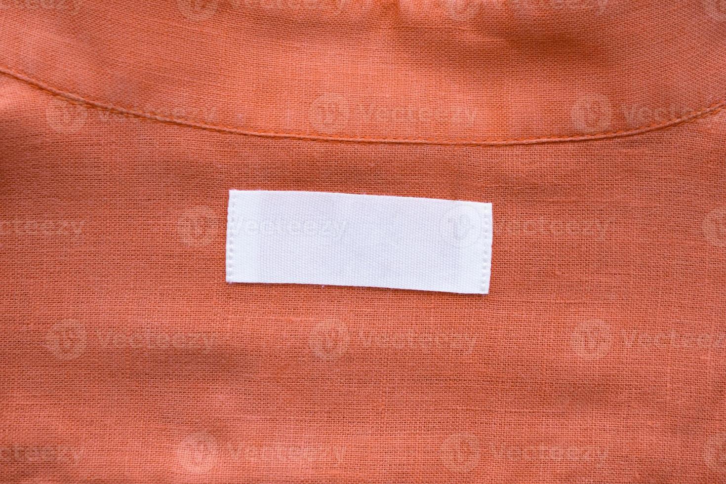 White blank clothing tag label on linen shirt fabric texture background photo