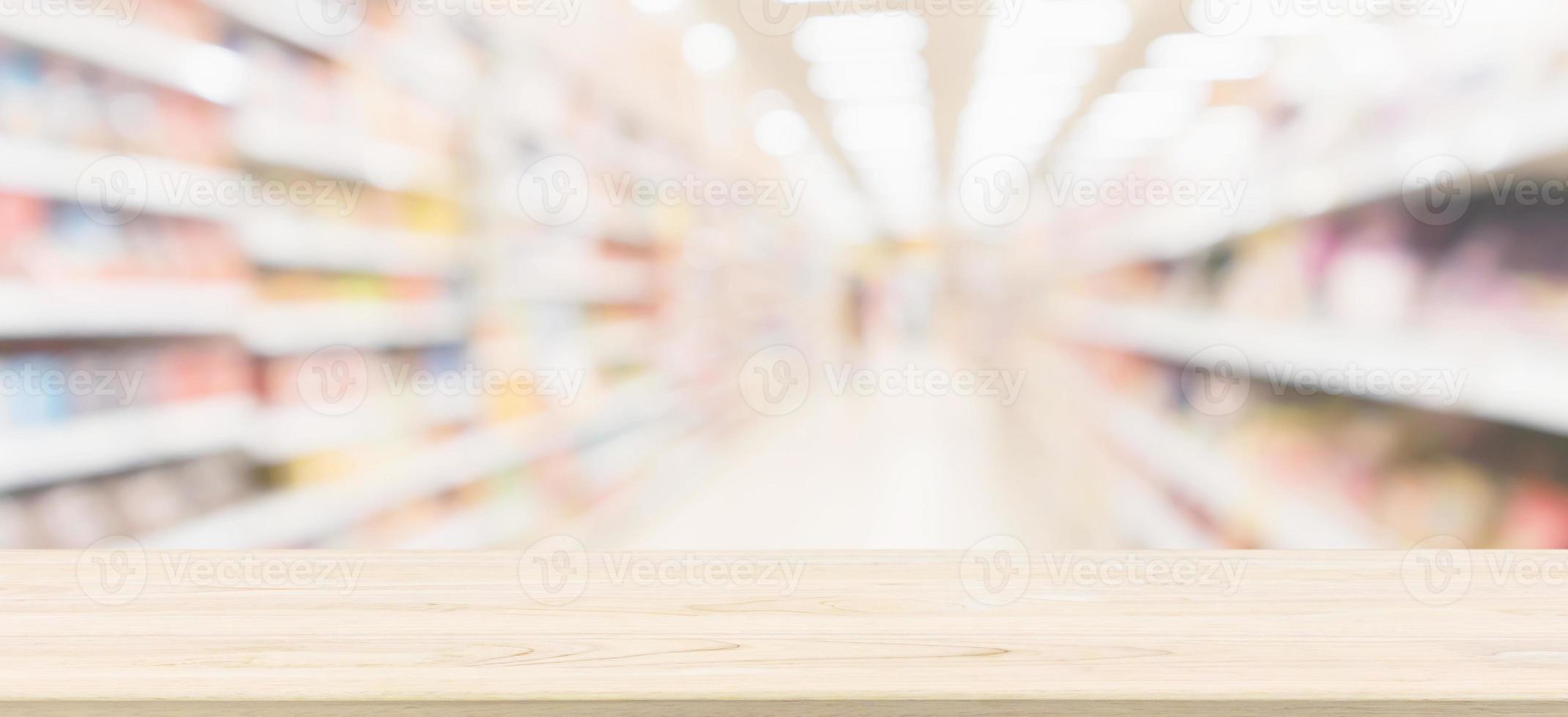Wood table top with supermarket aisle blur background for product display photo