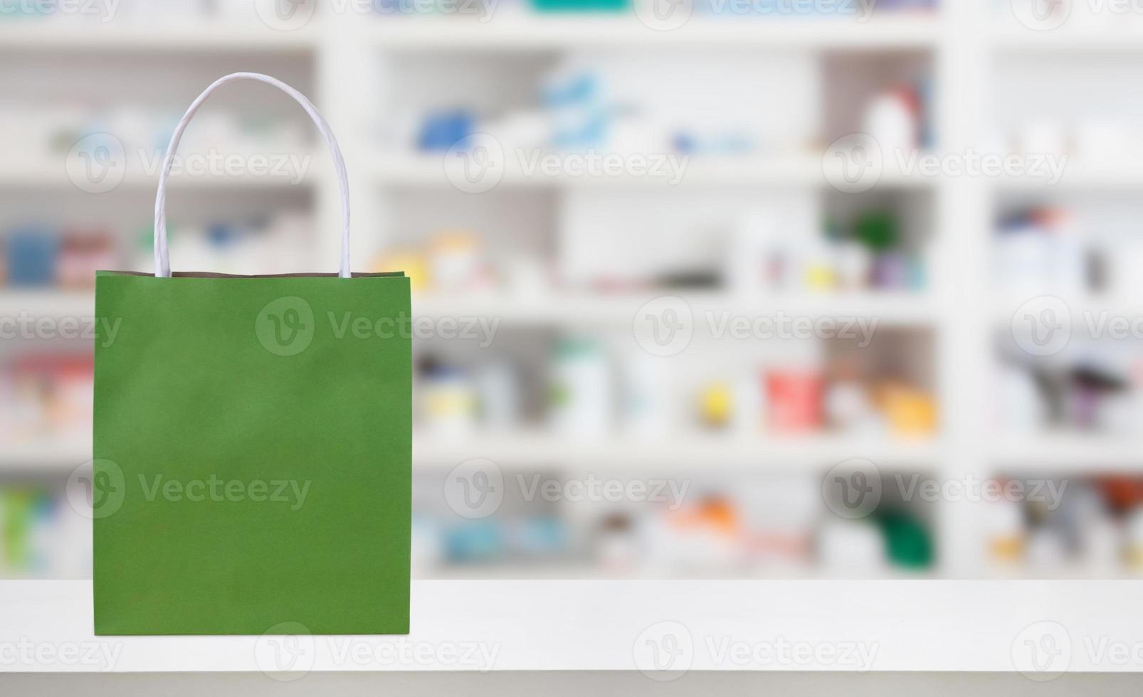 Paper bag on Pharmacy drugstore counter table with medicine and healthcare product on shelves blur background photo