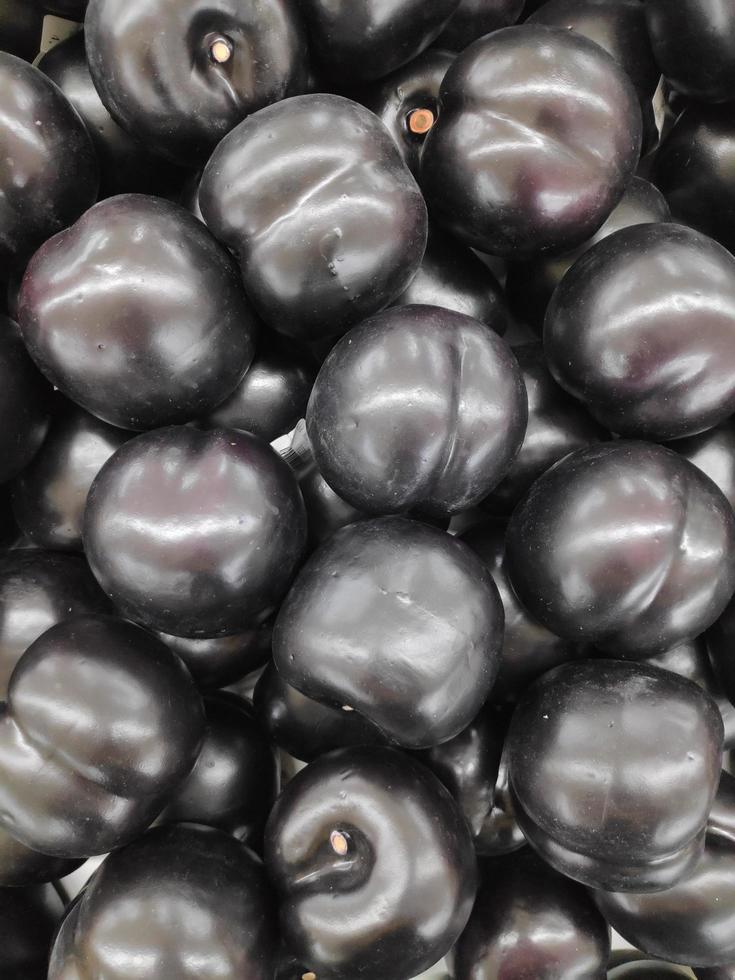 A bunch of fresh and healthy black plums photo