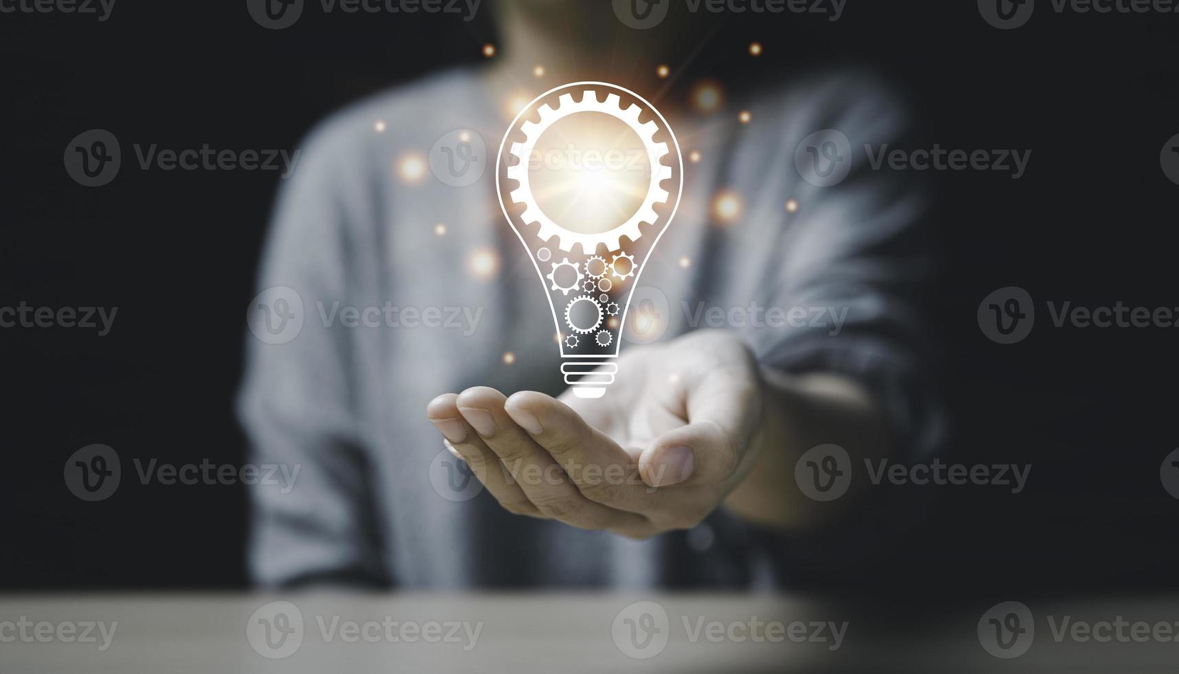 On the hand of a women with icon a light bulb And there is a gear icon on it. bright light bulb is idea innovation creativity inspiration brainstorming and imagination. technology education, photo