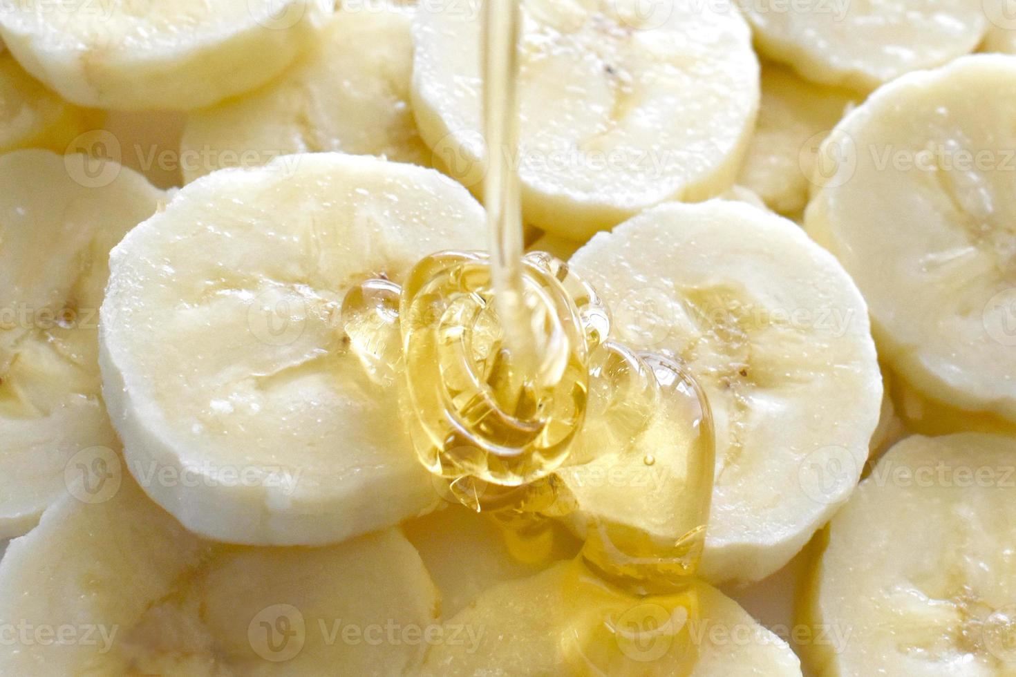 Banana and honey on a white plate. photo