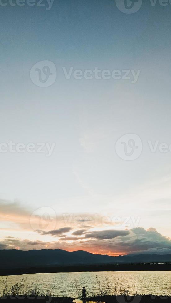 Silhouette of a man fishing in the afternoon. sunset on lake Limboto, Indonesia photo