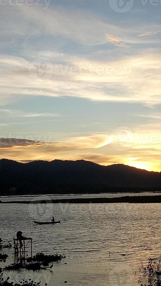 Silhouette of a man fishing in the afternoon. sunset on lake Limboto, Indonesia photo