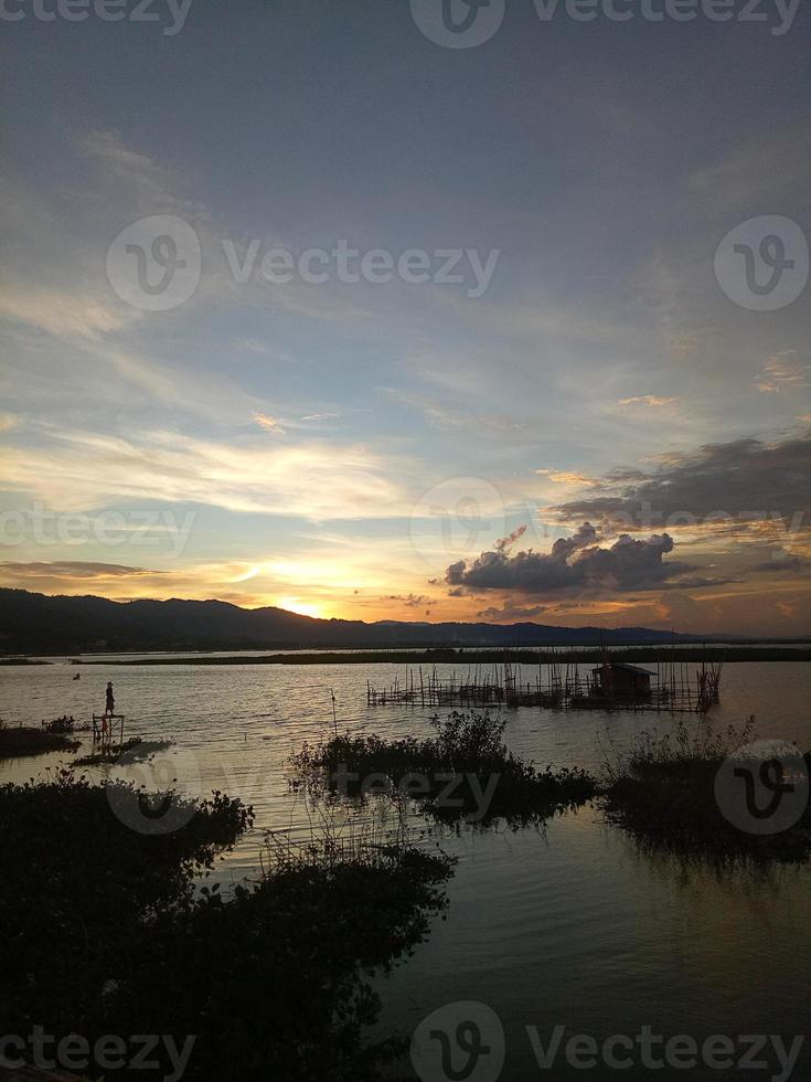 Silhouette of a man fishing in the afternoon. sunset on lake Limboto, Indonesia photo